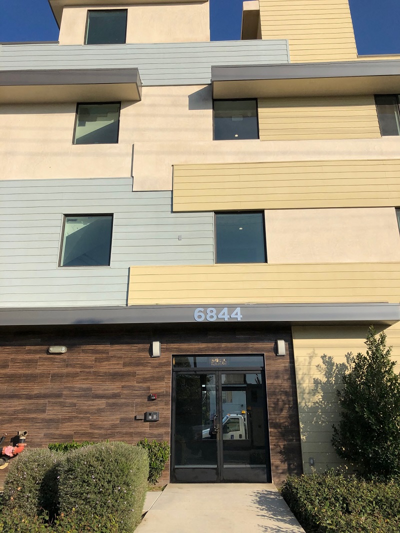 a building with a door and a sidewalk in front of it