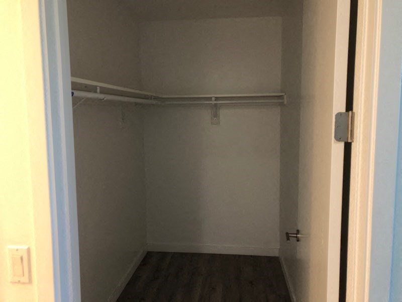a empty closet with a white wall and a door