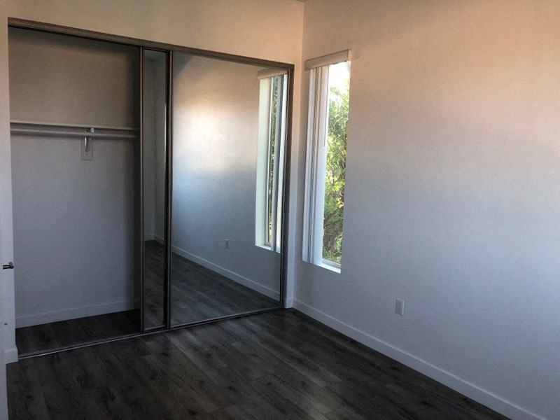 an empty room with a sliding glass door and a window