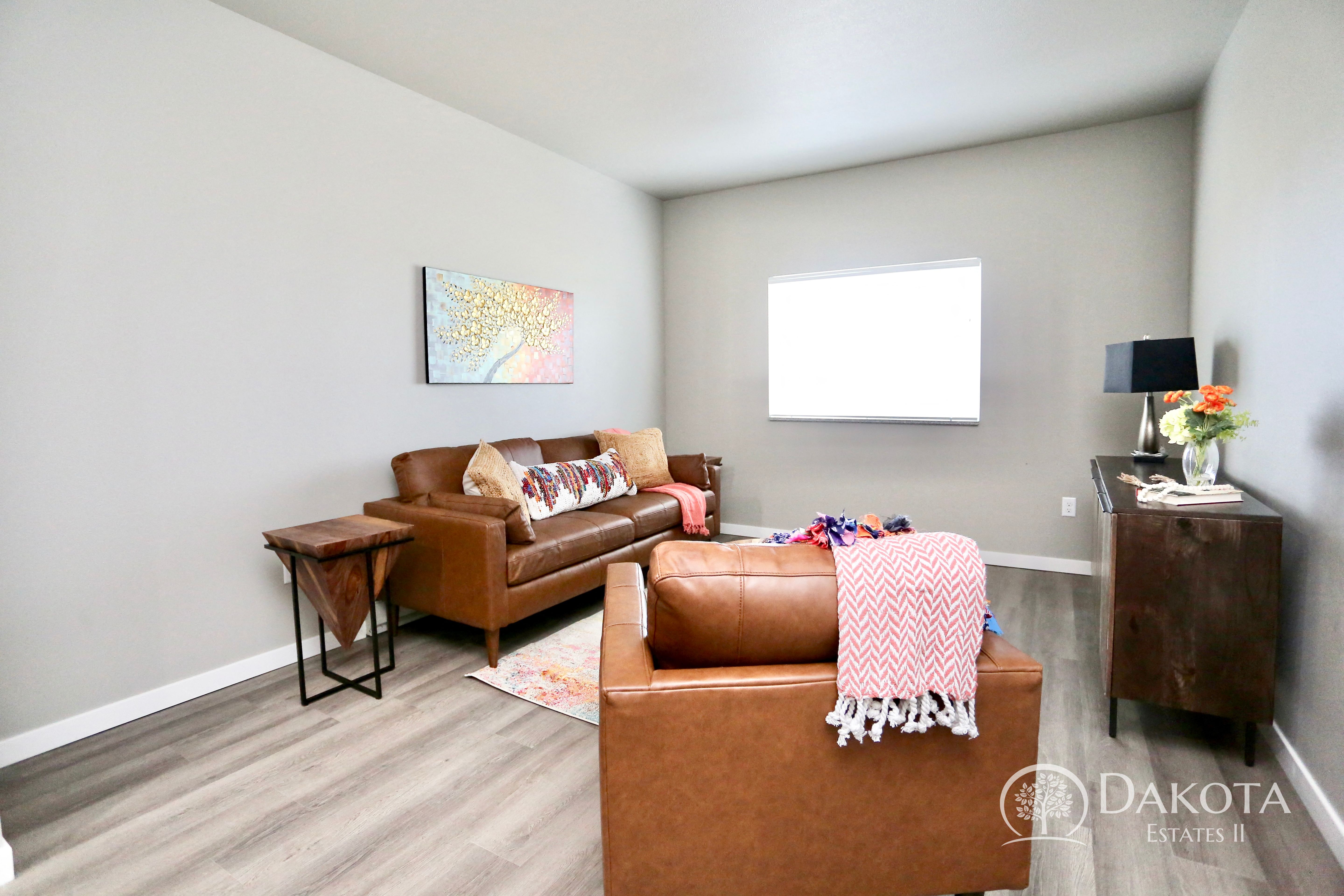 a living room with two brown leather couches and a tv