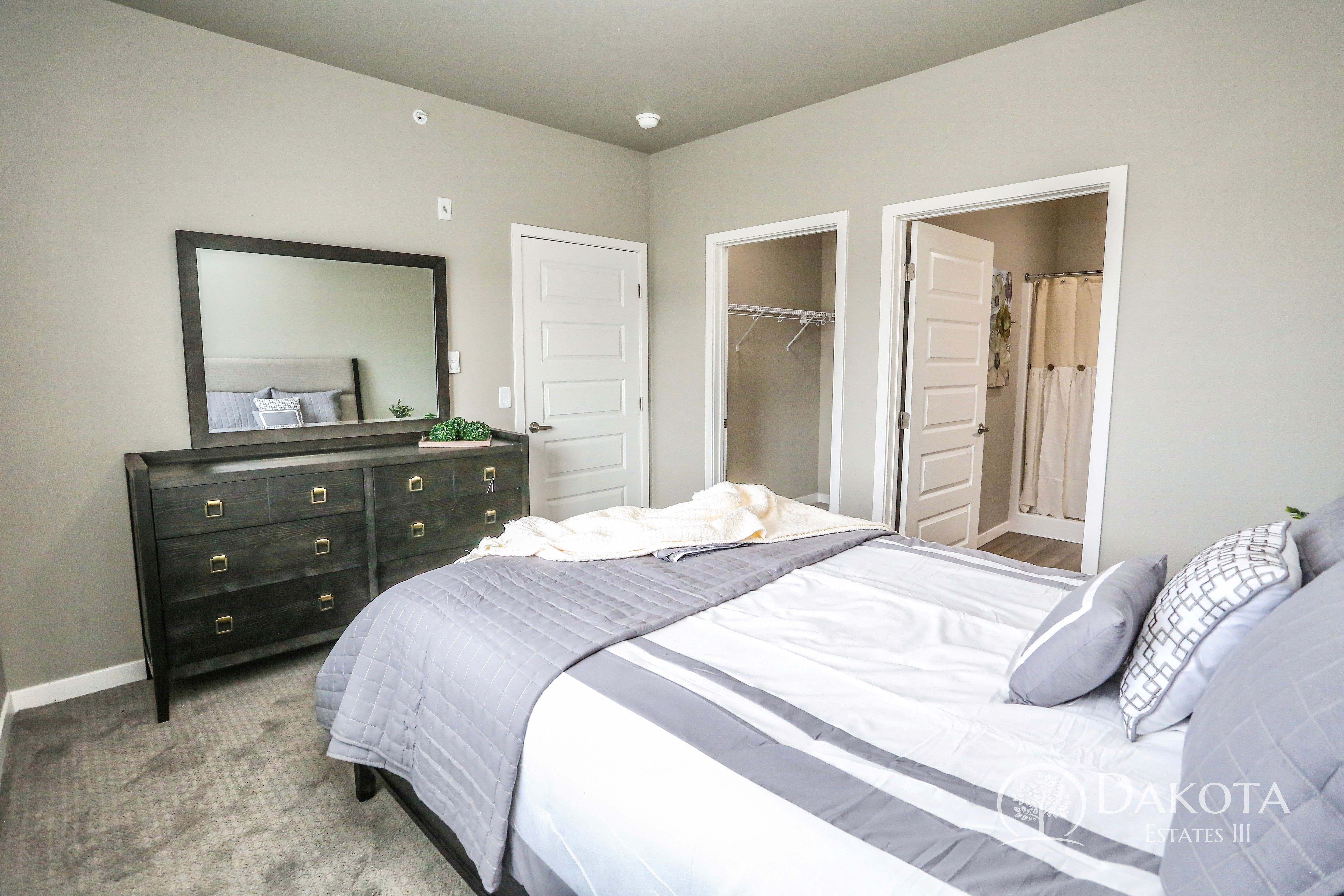 a bedroom with a bed and a dresser and a mirror