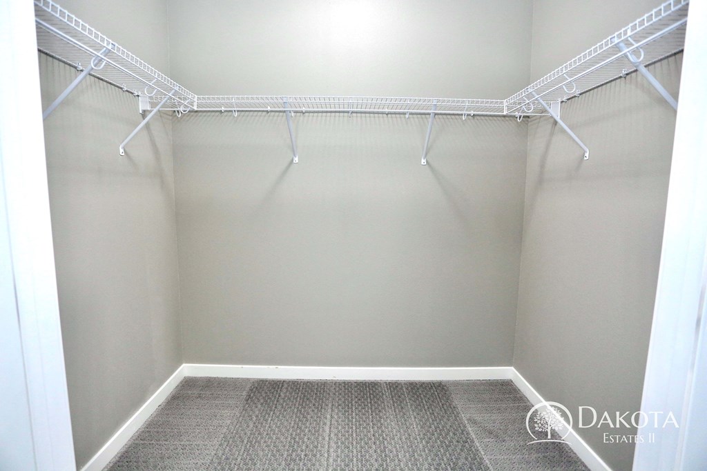 a empty closet with empty shelves and white walls
