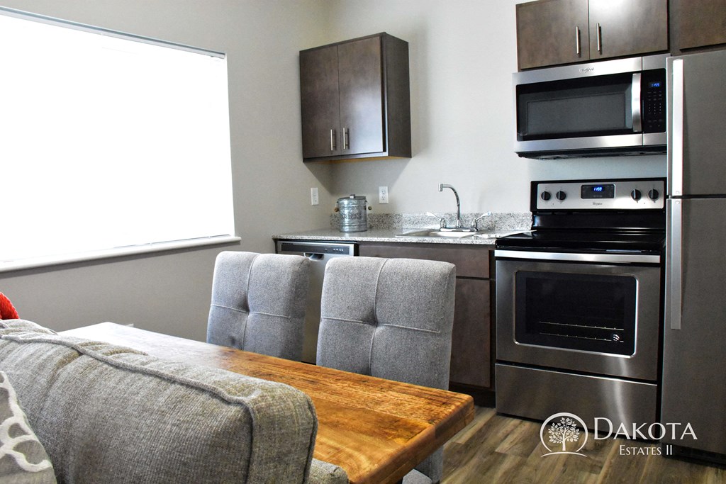 a kitchen with stainless steel appliances and a wooden table