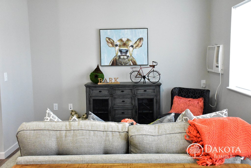 a living room with a couch and a painting of a cow