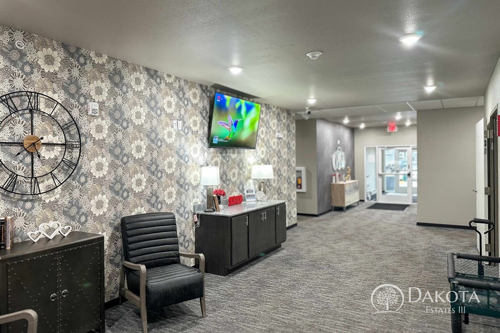 a lobby with a chair and a clock on the wall