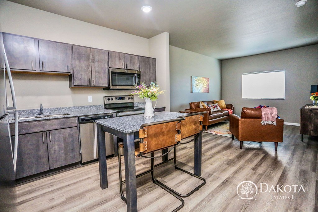 a kitchen with stainless steel appliances and a table with chairs