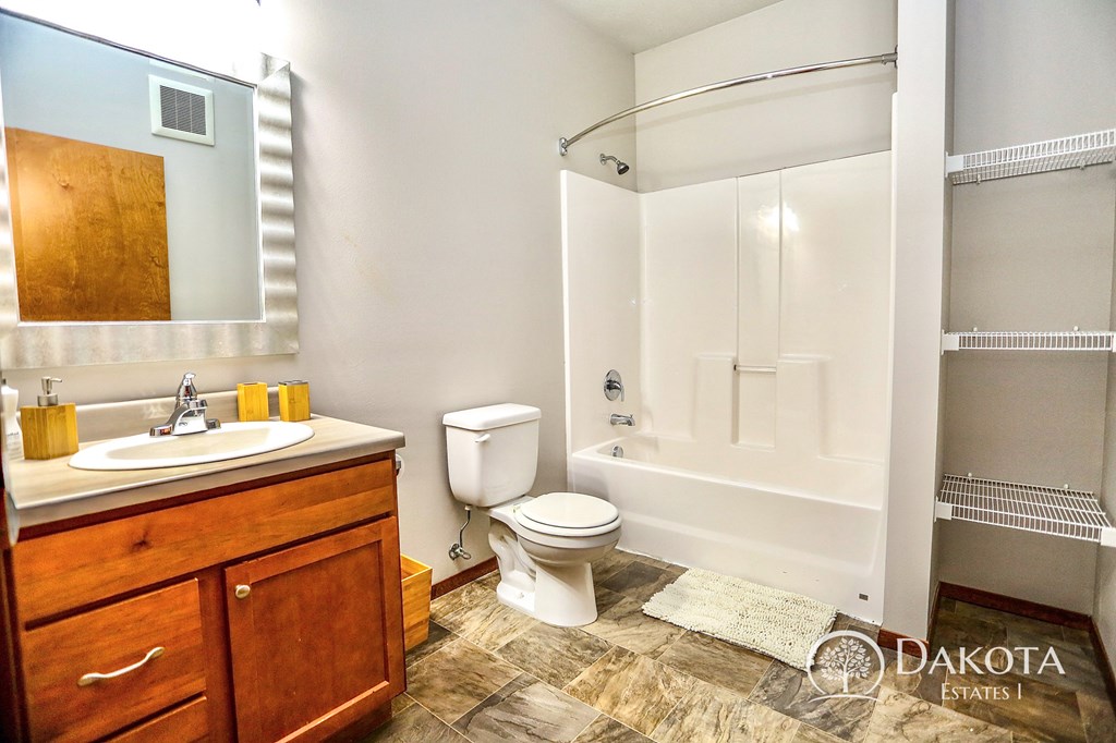 a bathroom with a shower toilet and sink and a mirror