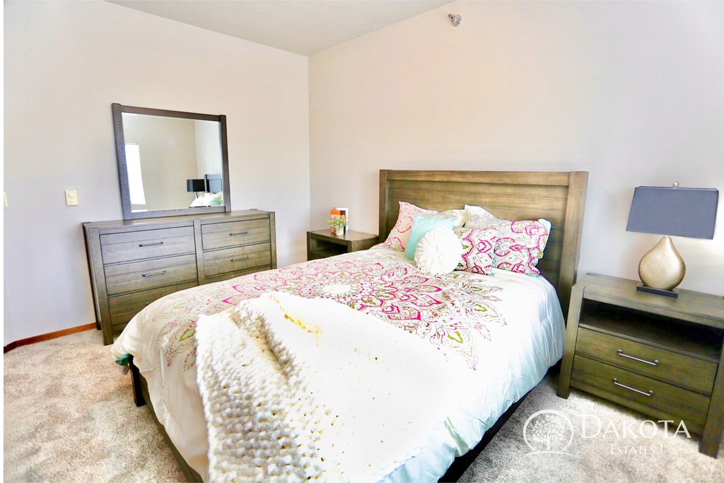 a bedroom with a bed and a dresser and a mirror