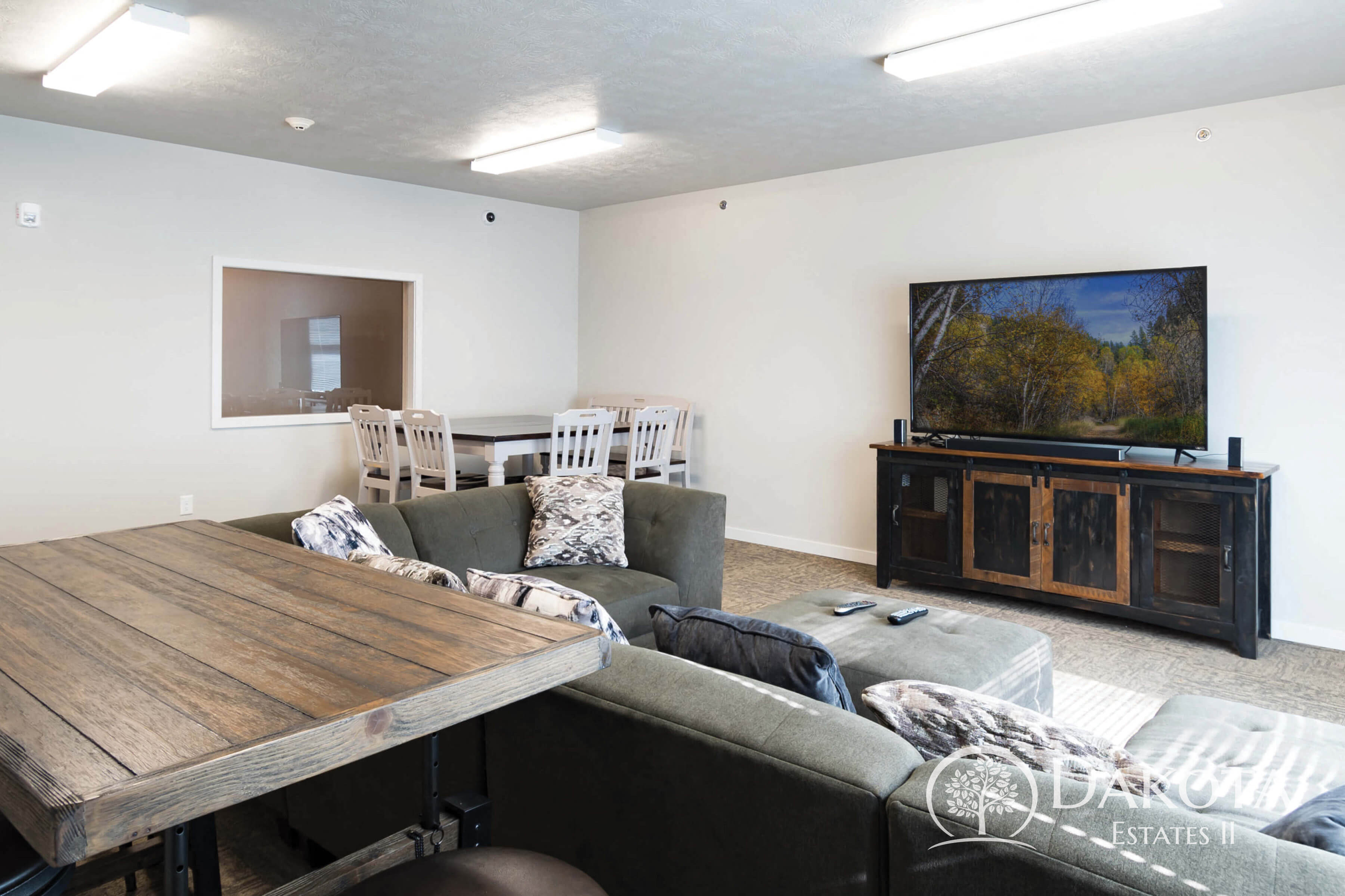 A living room with a wooden table and grey couch.
