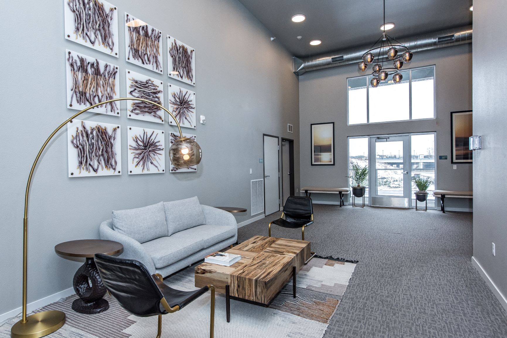 A living room with a grey carpet and a white sofa.
