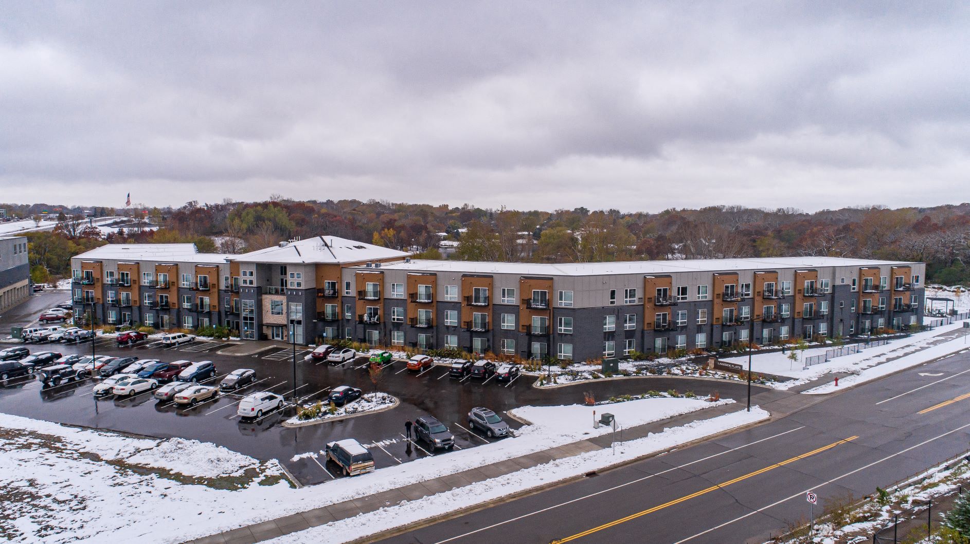 A parking lot with cars and apartment buildings in the background.