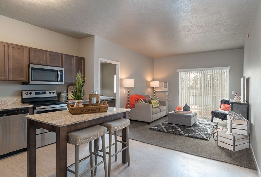 view of living room from kitchen with island with stools and living room with furniture