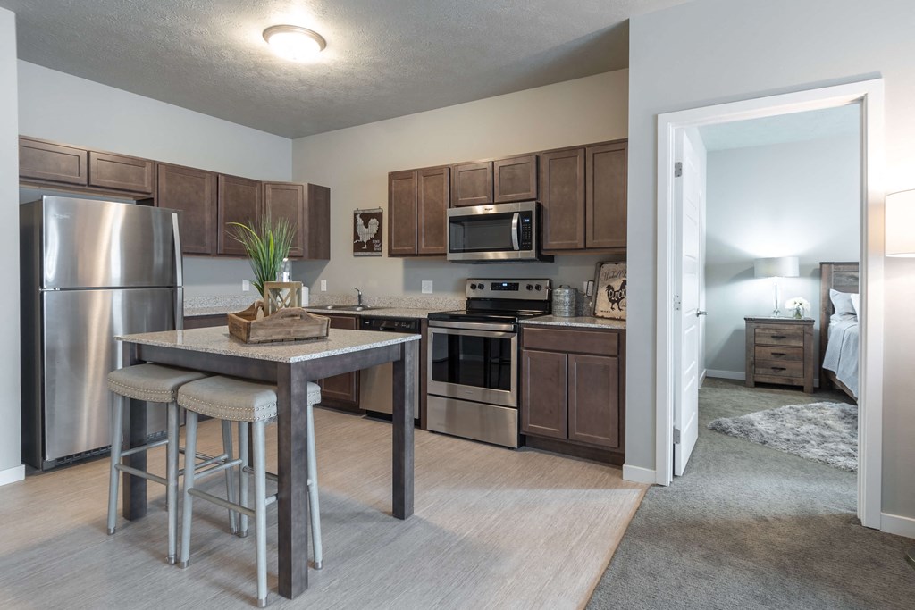 a kitchen with stainless steel appliances and a bar with stools