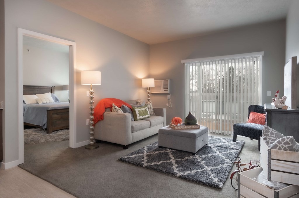 a living room with a couch and a chair in front of a window