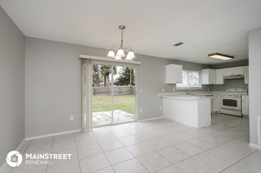 an open kitchen with a sliding glass door to the backyard
