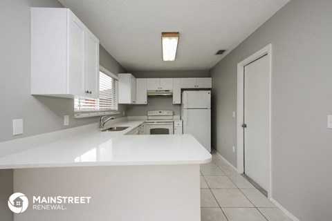 a white kitchen with white cabinets and a white counter top