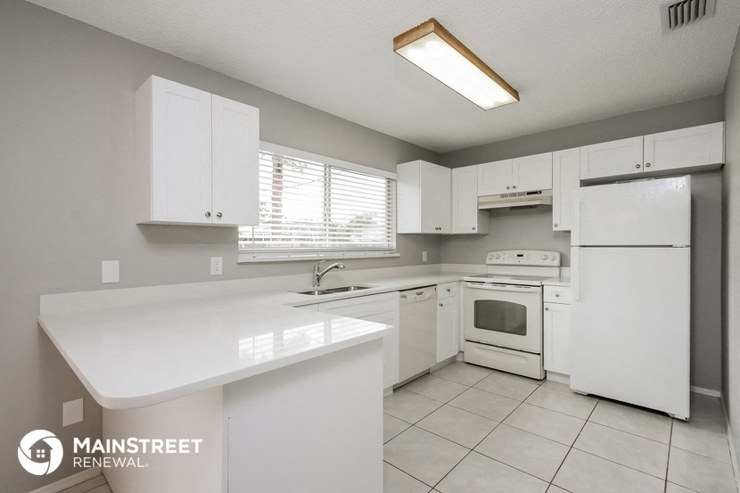 a white kitchen with white appliances and white counter tops
