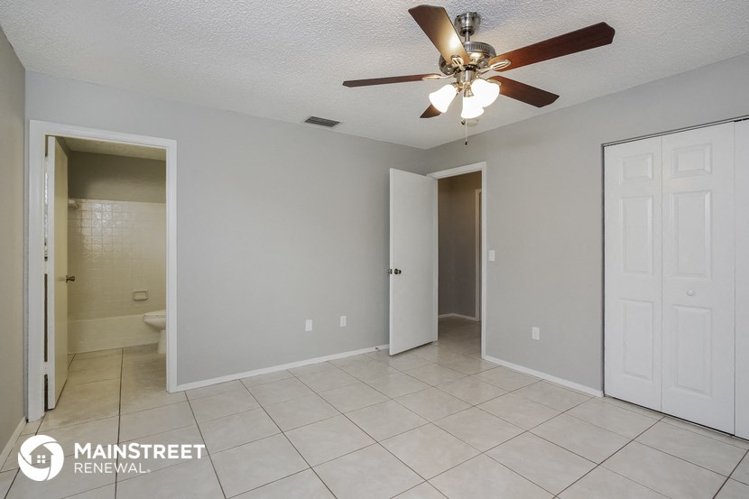 a bathroom with a ceiling fan and a tiled floor