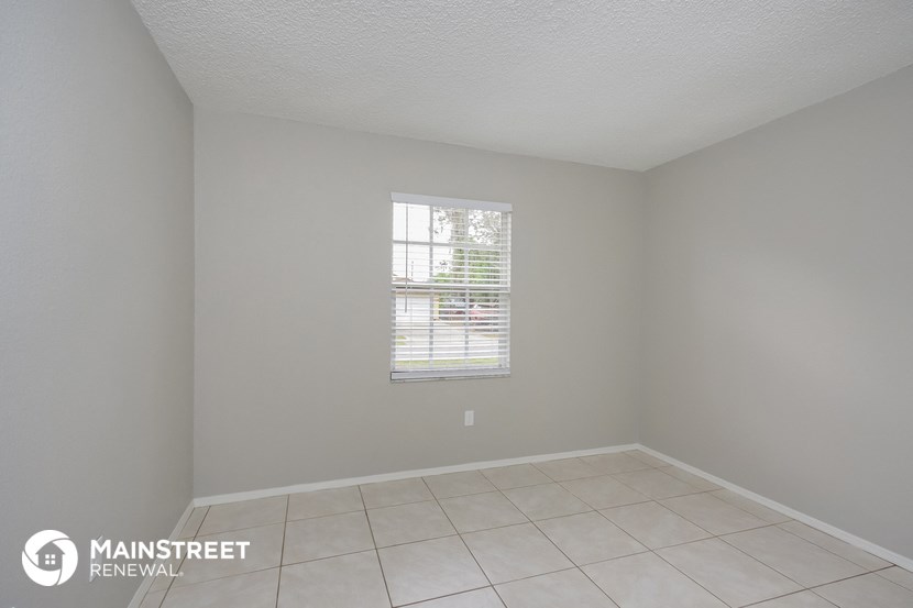 an empty room with a window and a tiled floor