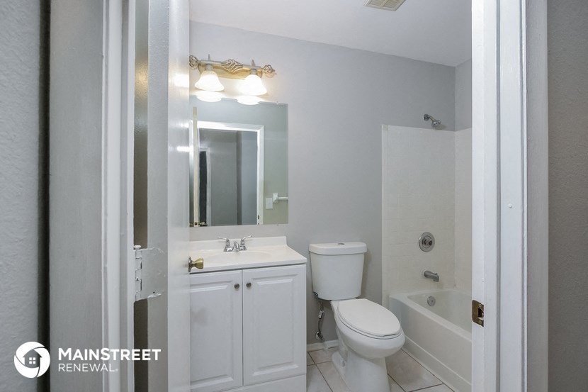 a white bathroom with a sink toilet and a mirror