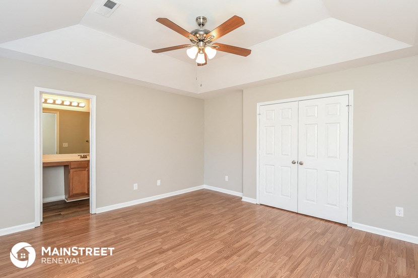 the living room of an empty house with a ceiling fan