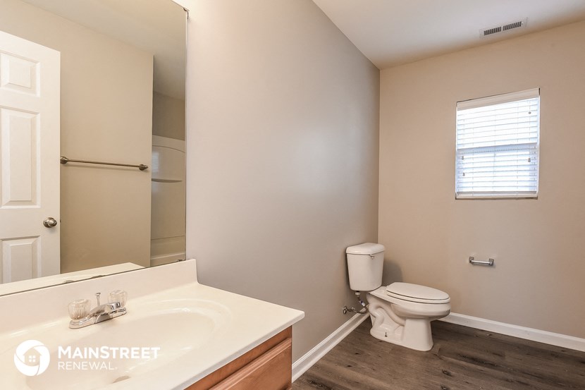 a bathroom with a toilet and a sink and a mirror