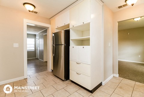 a kitchen with a stainless steel refrigerator and white cabinets
