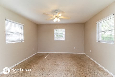 the master bedroom has a carpeted floor and a ceiling fan