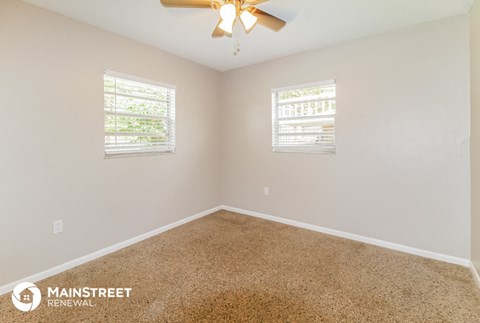 the master bedroom has a carpeted floor and a ceiling fan