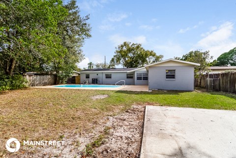a backyard with a pool and a white house