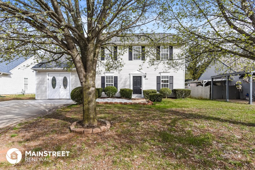a white house with a large tree in front of it