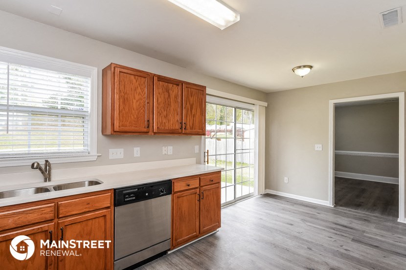 a kitchen with wooden cabinets and a stainless steel dishwasher