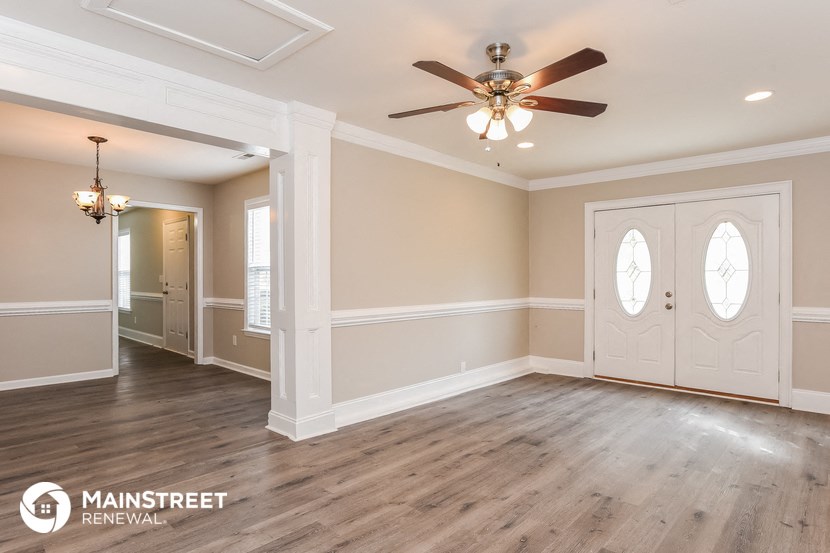 an empty living room with white walls and a ceiling fan