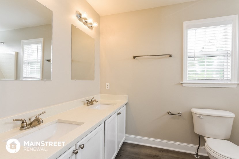 a bathroom with a toilet and a sink and a mirror
