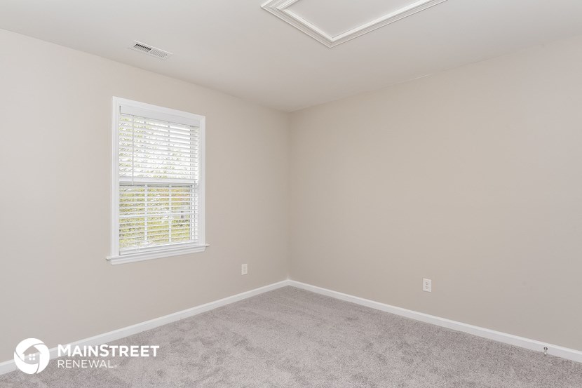 the upstairs bedroom with carpet and window