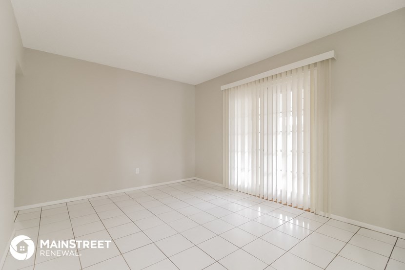 an empty living room with white tiled floor and white curtains