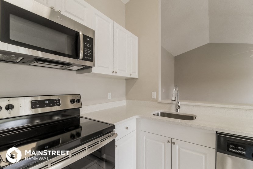 a kitchen with white cabinets and appliances and a sink