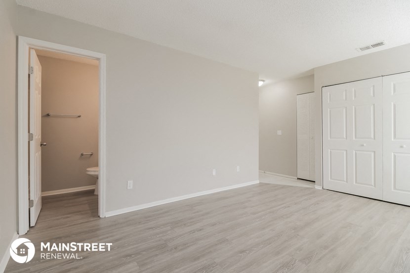 the spacious living room with a door to the bathroom