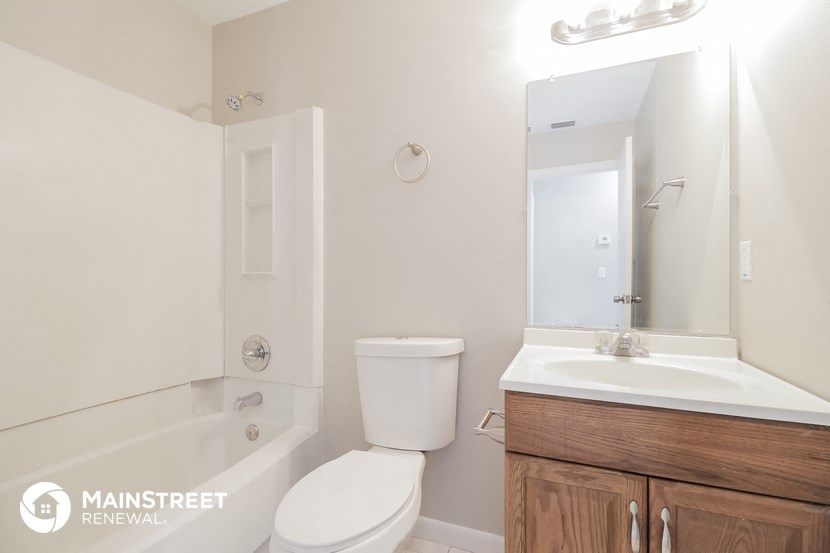a bathroom with a toilet sink and tub and a mirror