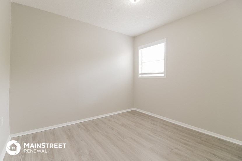 the interior of an empty room with white walls and a window