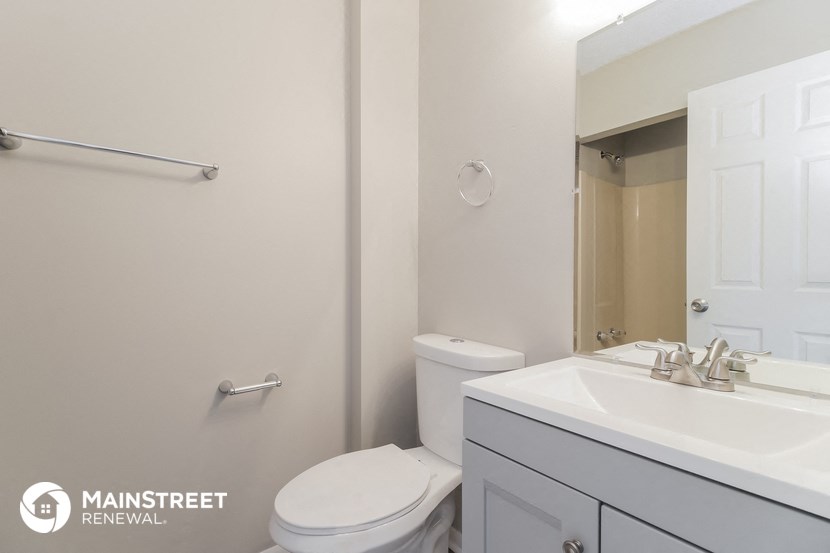 a white bathroom with a toilet sink and mirror