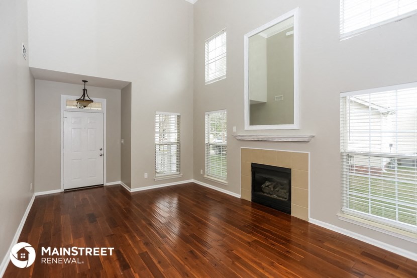 the living room with wood flooring and a fireplace