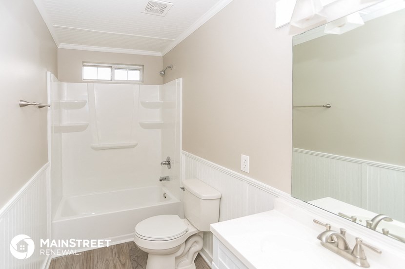 a bathroom with a white toilet and a tub and a sink
