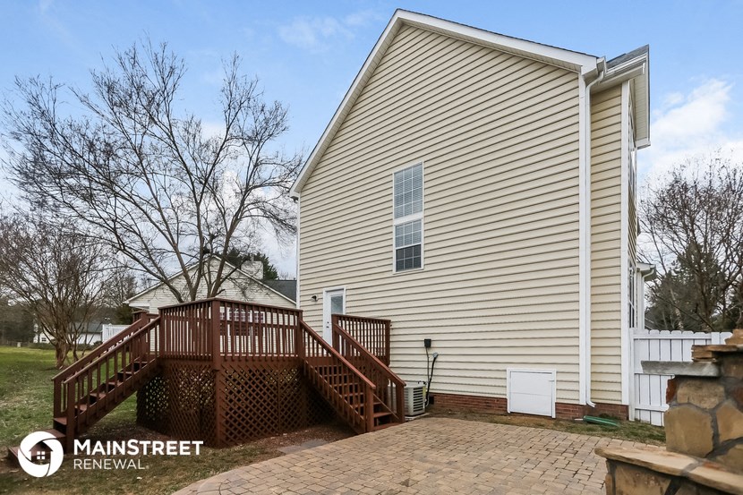 the outside of a house with a wooden deck