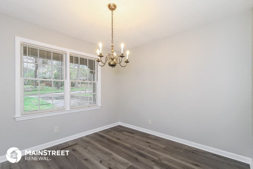 the living room of a home with a large window and a chandelier