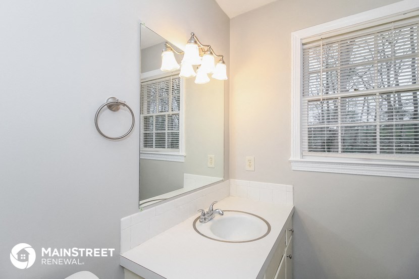a bathroom with a sink and a mirror and a window