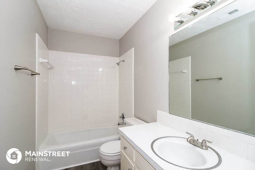 a bathroom with a sink and a toilet and a bath tub