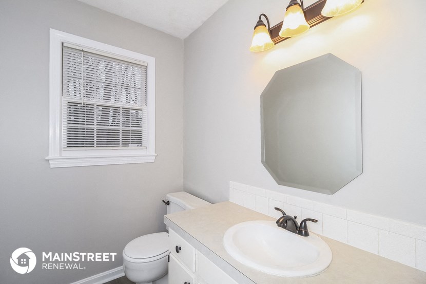 a bathroom with a sink and a toilet and a window