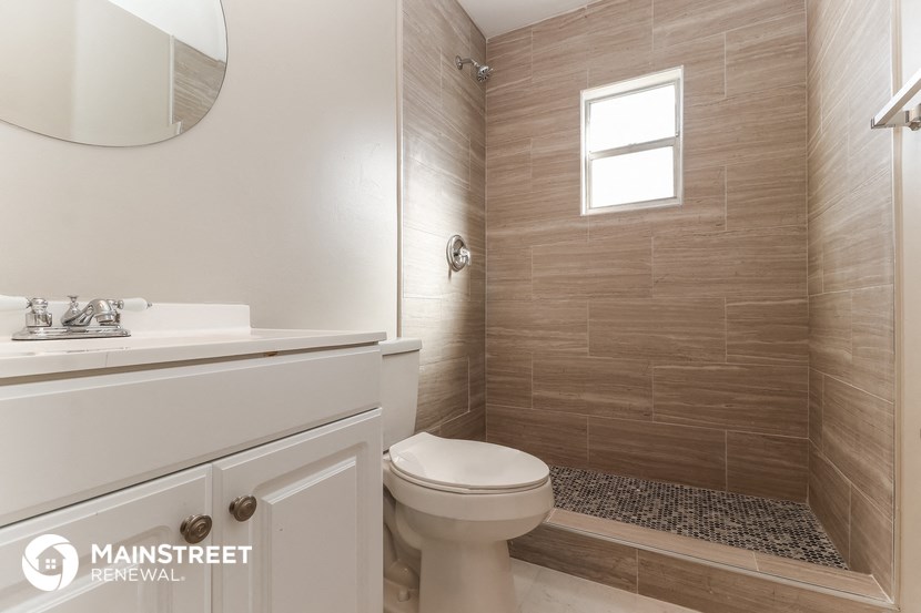 a bathroom with a shower and a toilet and a sink