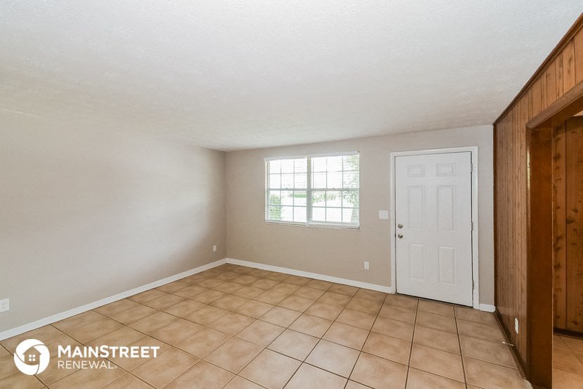 the kitchen of a home with a tile floor and a white door